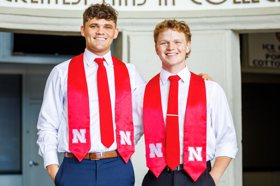 Brady Moylan (left) and Ben Hastreiter reveal themselves as the students in the Lil' Red and Herbie mascot uniforms. They will graduate May 17. 