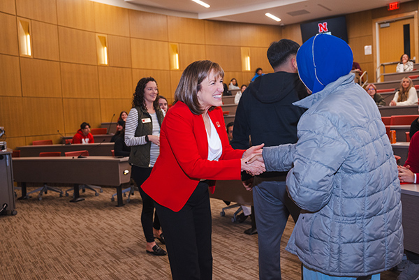 Kathy Farrell shakes hands with a student.