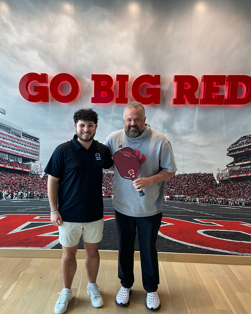 Katsaounis presented Husker Head Football Coach Matt Rhule with a pickleball paddle.