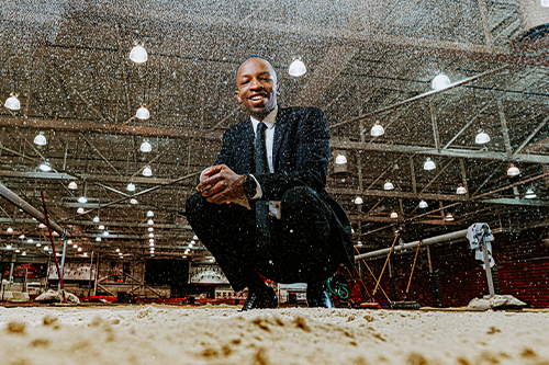 Passmore Mudundulu poses in a track sand pit dressed in a suit.